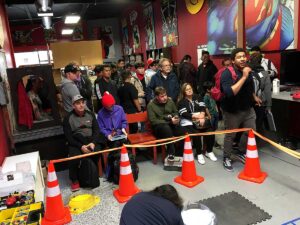 crowd watching beyblade matches at tournament in comic book shop