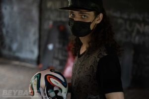 man wearing hat and mask holding soccer ball