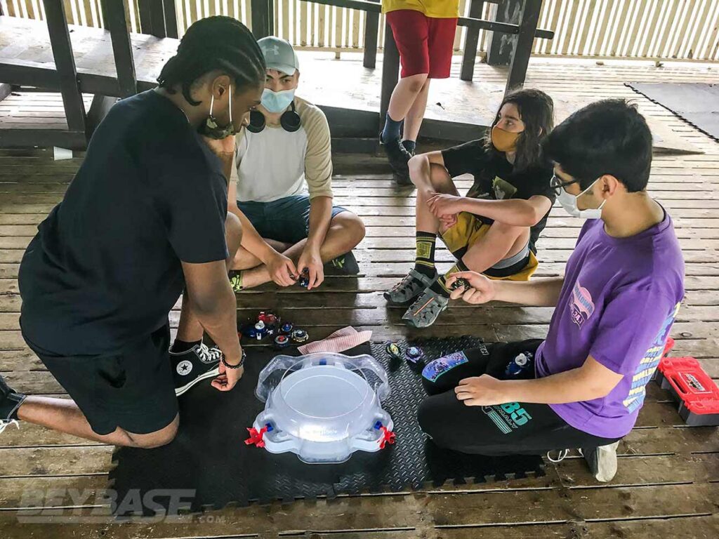 beyblade players inspecting decks beside stadium before match