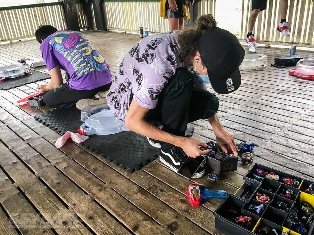 beyblade players facing away from each other preparing before match