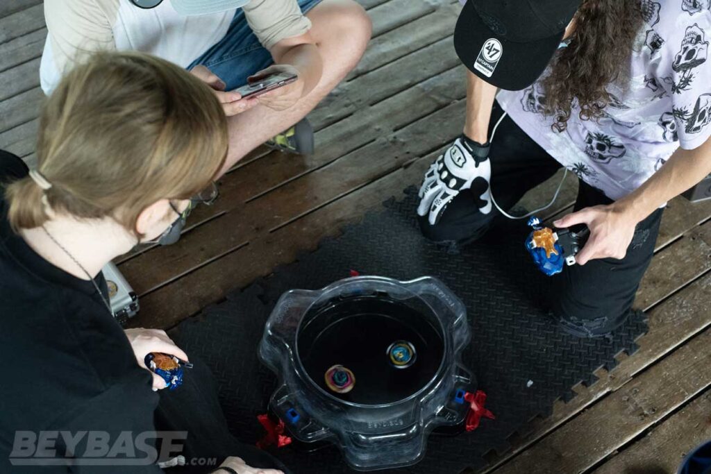 overhead view of kei and 1234beyblade looking down at beyblades in stadium