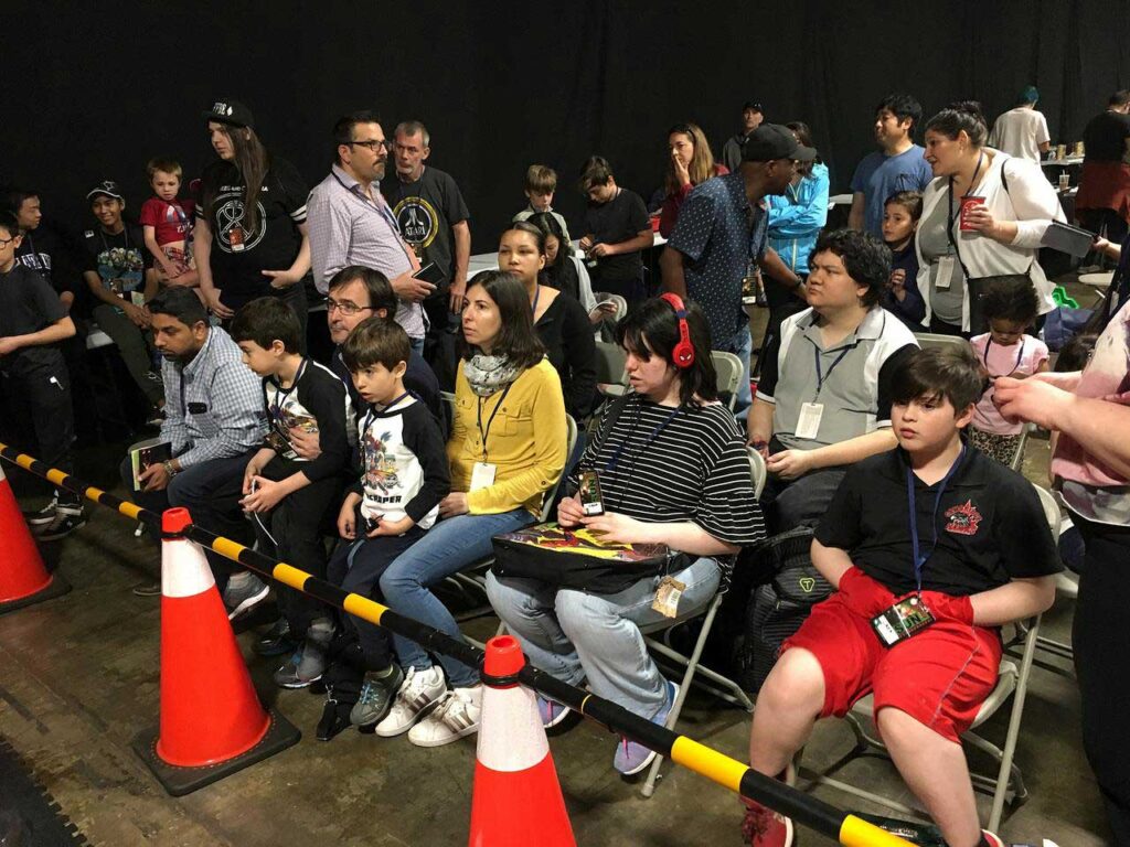 people sitting in the front row of chairs in front of pylons and barriers