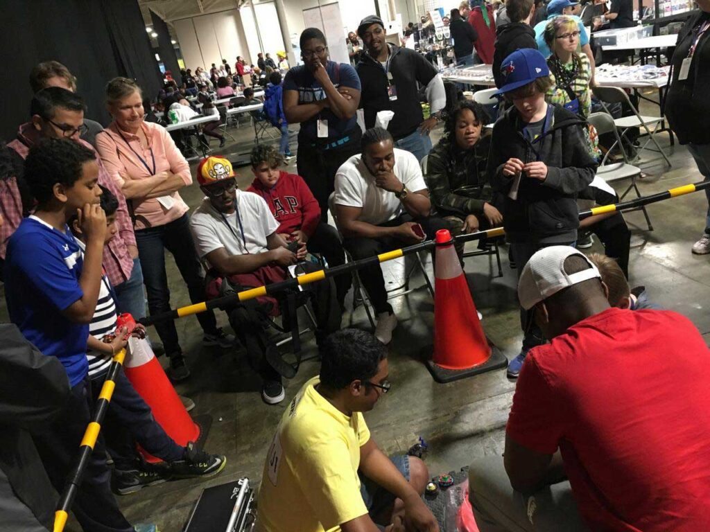 spectators watching battle in the finals of beyblade tournament