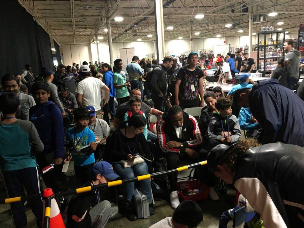 large group of people sitting on chairs within beyblade tournament area